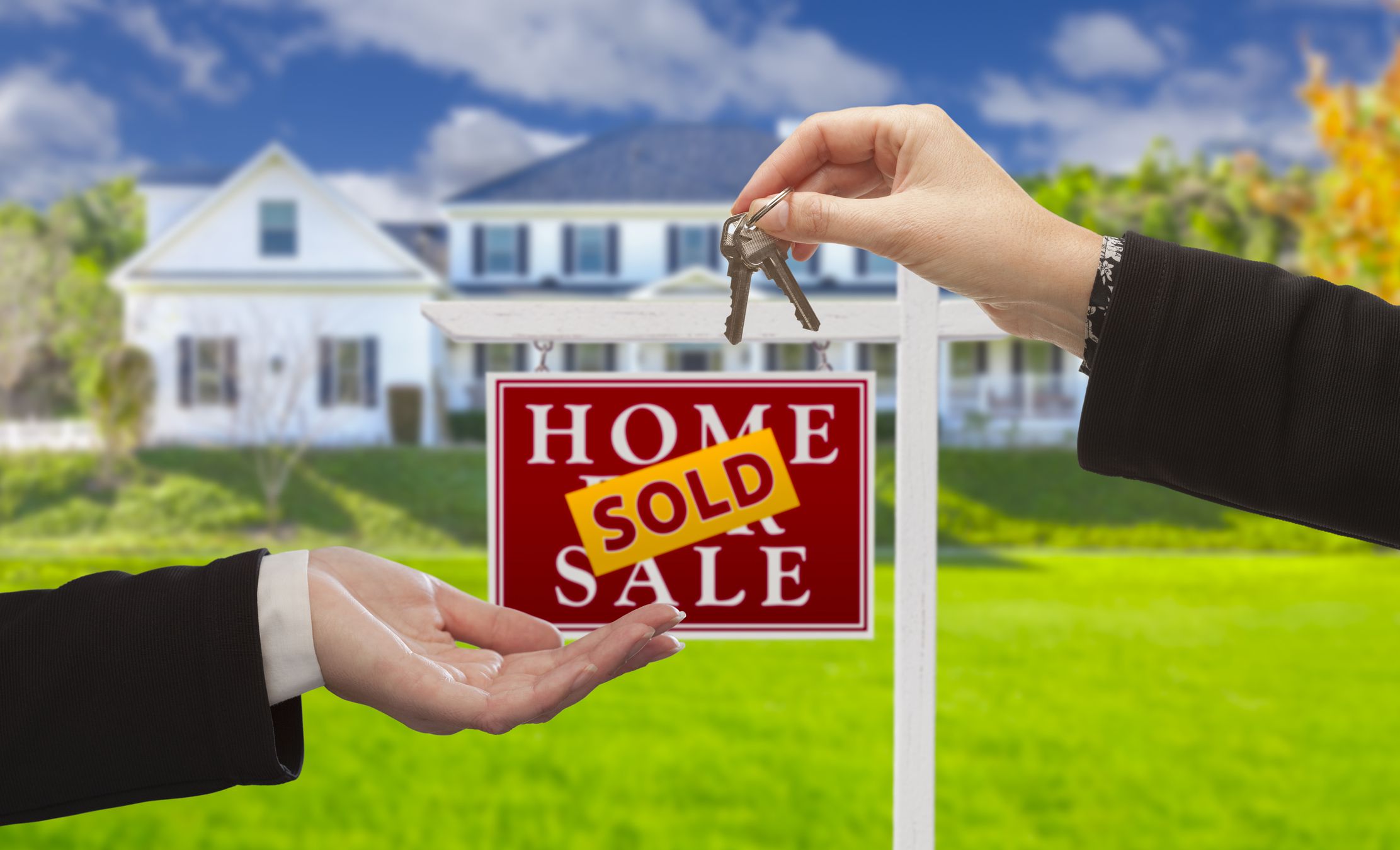 Sold Real Estate Sign and Agent Handing Over Keys to New Home. Sold Real Estate Sign and Agent Handing Over Keys to New Home.